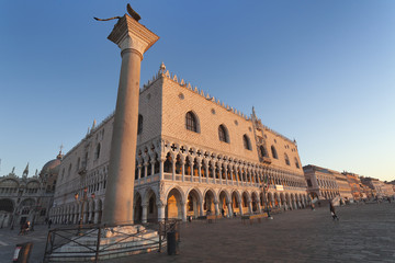 Fototapeta na wymiar Two symbols of Venice: winged St Mark Lion on its column and Doge's palace at sunrise, Italy, Europe