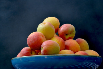 blue dish with red and yellow apricots