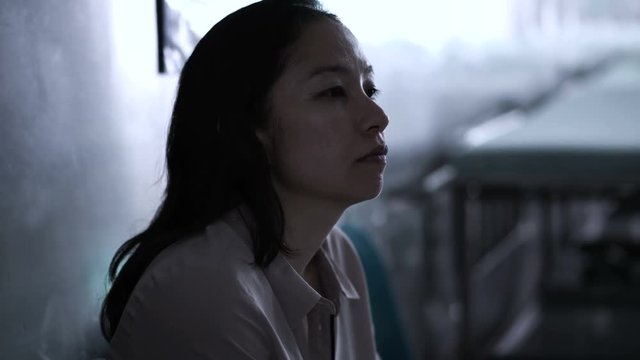 Asian woman sitting alone in hospital. Worried and  anxious from thinking of bad news 4K