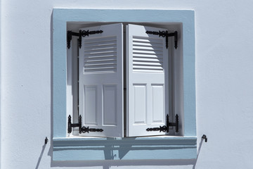 Whit painted window with light blue frame and white shutters