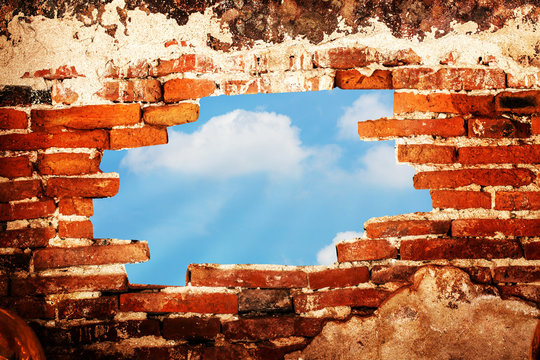 Broken Brick Wall With Sky View Through The Hole