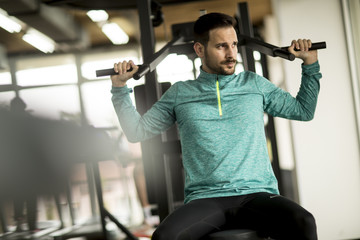 Young man exercise on an exercise machine at the gym