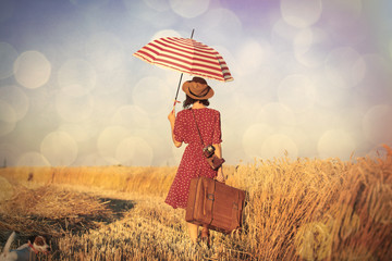 young woman with umbrella and suitcase