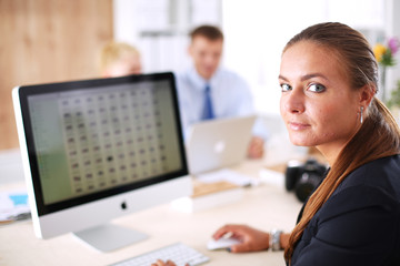 Fashion designers working in studio sitting on the desk
