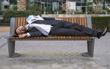 businessman fallen asleep on a bench at  Dubai Marina