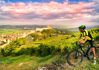 Cyclist admires the Soave castle views.