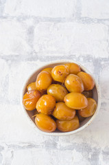 Raw fresh dates in a bowl on brick wall background close up. Selective focus.