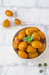 Raw fresh dates and green mint in a bowl on brick wall background close up. Selective focus.