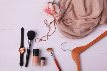 Flat lay woman clothing and accessories placed on a wooden background