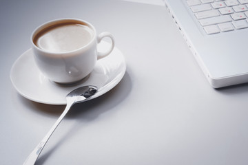 A cup of coffee with Laptop on the desk