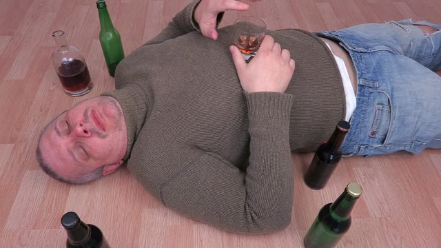 Drunk man with hangover sleeping on floor