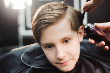 Fototapeta premium cute young boy getting a haircut