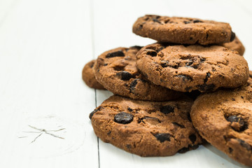 Chocolate cookies on a white wooden table, space for text.