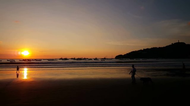 People walking at sunset on the beach of San Juan del Sur