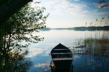 Rowing boat floating over the Lake Selment Wielki waters. Masuria, Poland. - obrazy, fototapety, plakaty