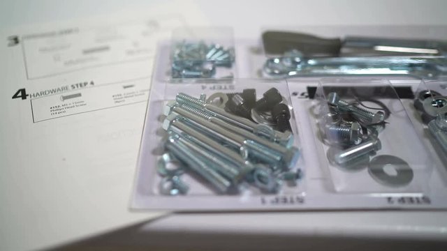 Checklist and assembly hardware kit including screws, bolts, washers and tools for assembling elliptical trainer