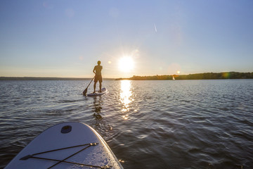 Standup paddler im Sonnenuntergang