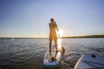 Standup paddler im Sonnenuntergang