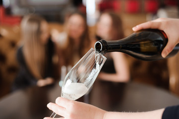 Man pours champagne in wineglasses