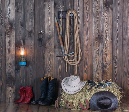 Cowboy hat, boots and weapons on the background of the old barn.Wild west, cowboy,Vintage