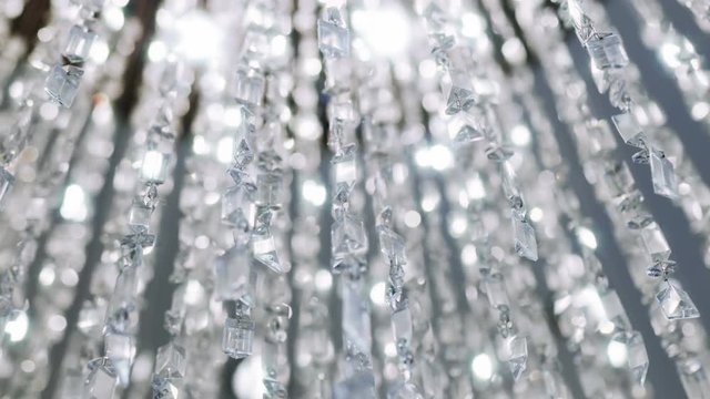 Crystal chandelier. Big classic crystals. 
Low angle shot of a big beautiful crystal luxury chandelier. With bling bling shining reflection.

