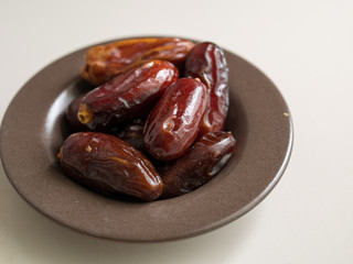 Dates fruit in a plate on wooden