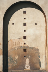 Arch Frame Surrounds Old Dilapidated Church Wall with Cross