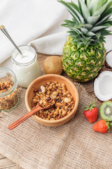Granola with Greek yoghurt and fruit on a wooden background in a rustic style