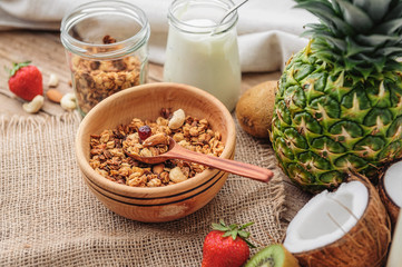 Granola with Greek yoghurt and fruit on a wooden background in a rustic style