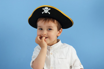 niño pequeño mordiendo las uñas con sombrero pirata
