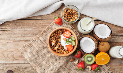 Granola with Greek yoghurt and fruit on a wooden background in a rustic style