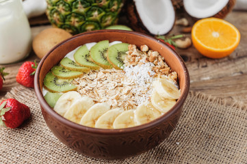 Granola with Greek yoghurt and fruit on a wooden background in a rustic style