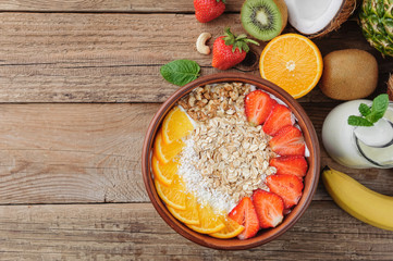 Granola with Greek yoghurt and fruit on a wooden background in a rustic style