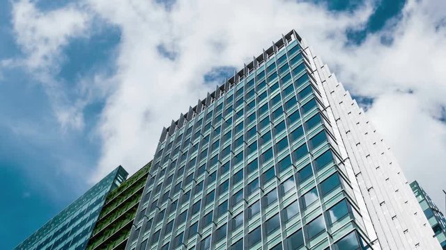 Office building with sun flare and cloud reflection 4K wide shot
Attractive office building timelapse background with fast moving cloud.

