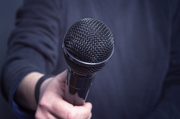 Journalist making speech with microphone and hand gesturing concept for interview.