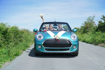 Fototapeta premium Just married couple driving convertible car