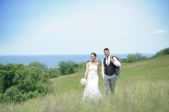 Bride And Groom Walking On Hill