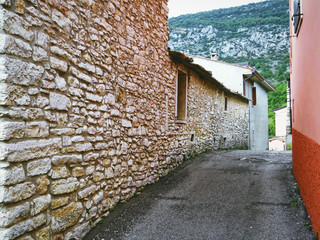 Narrow street with stone house walls