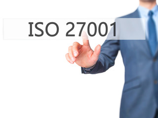 ISO 27001 - Businessman hand pressing button on touch screen interface.