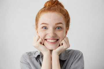 Tell me more. Close up shot of curious 20 y.o. redhead Caucasian woman pillowing face on her hands...