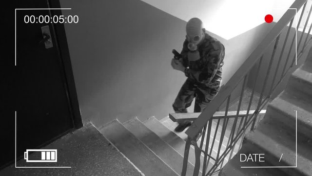 Guard dressed in military uniform in a gas mask. the storming of the building .surveillance camera.