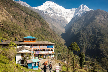 Turyści na szlaku przez Chhomrong i widok na Annapurnę.
