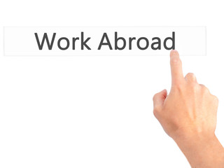 Work Abroad - Hand pressing a button on blurred background concept on visual screen.