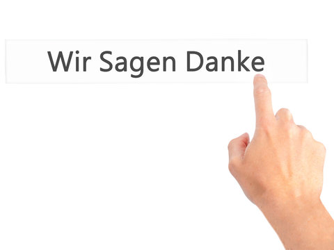 Wir Sagen Danke (We Say Thank You In German) - Hand pressing a button on blurred background concept on visual screen.