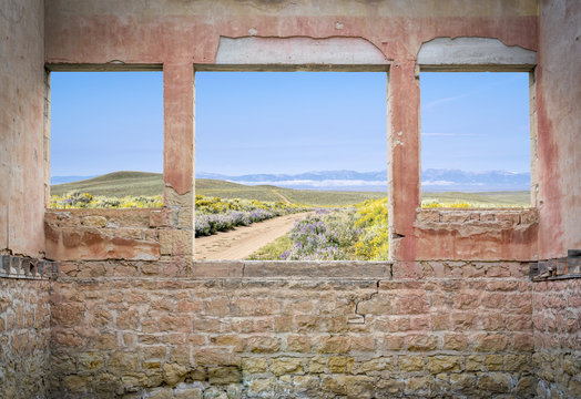 Fototapeta ranch road through mountain valley  - window view