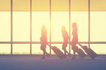 travel concept, people in the airports ,Silhouette of young girl with luggage walking at airport, women showing something through the window,selective focus,vintage tone color