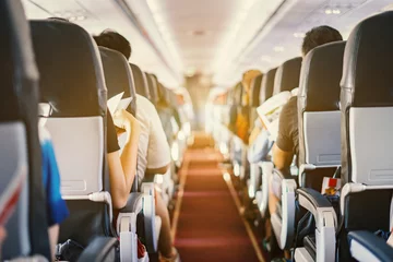 Foto auf Acrylglas Flugzeug Passagiersitz, Innenraum des Flugzeugs mit Passagieren, die auf Sitzen sitzen und Stewardess, die den Gang im Hintergrund gehen. Reisekonzept, Vintage-Farbe, selektiver Fokus