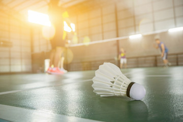 sports concept.Badminton ball (shuttlecock) and racket ,badminton courts with players competing modern gym in background,selective focus,vintage color