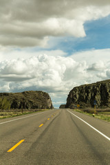 Highway With Rock Formations and Clouds Above