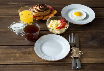 Breakfast table served with corn porridge, fried egg and juice